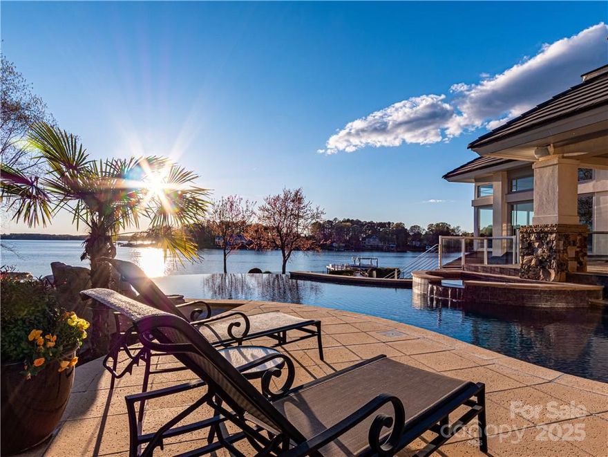 A flawless Harry Schrader design situated on the Lake Norman point of gated Connor Quay in Cornelius, NC, its panoramic views, approximately 275 ft of shoreline & breathtaking sunsets, truly bring the outdoors in. Infinity pool on main level eliminates traversing a basement to enjoy. Magnificent vaulted great room w/dazzling lake views has wall of windows and is open to the chef's kitchen complete with massive prep island, high-end appliances, computer station and breakfast area which opens to covered outdoor dining, pool, breezeway, outdoor kitchen & NanaWall pool house. Bright, open dining room offers shimmering views. Main floor office makes for easy commute & the over sized master-on-main boasts private covered waterfront terrace and luxurious bath. Floating stairway leads to lower level fitness, bedroom, billiard, media, bar & wine cellar. Elevator to all levels, light American Cherry floors, enviable storage, 4 car garage. 25 minute commute to Charlotte's international airport.