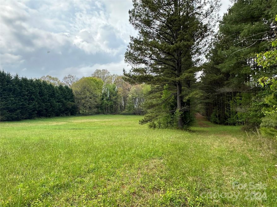 5 acres in a desirable West Iredell location. The acreage features 200' of road frontage on Gilbert Road with a tree lined driveway cut into the land. The land has approximately 2.5 acres cleared with woods to the rear. County water and gas available. Survey from 2018 on file. Agent Is related to seller.