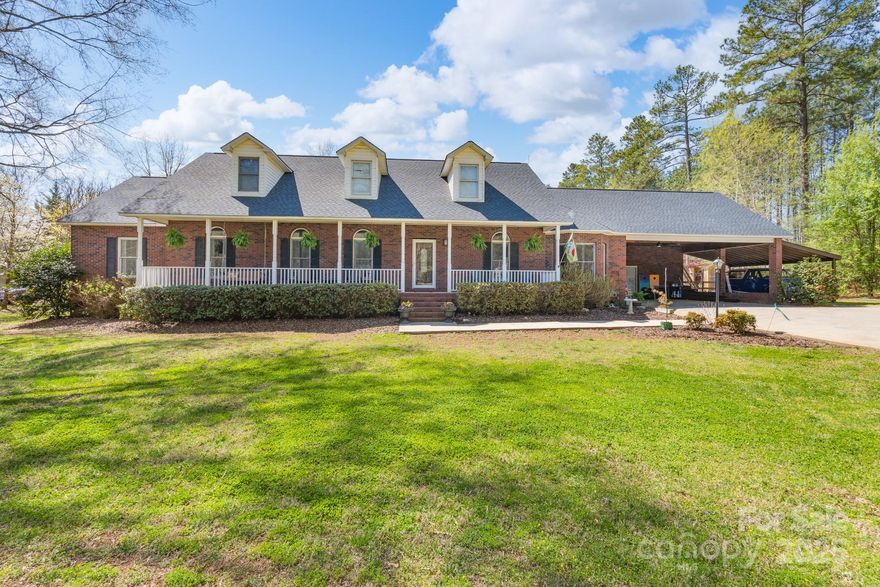 Located in the middle of over two acres, this all-brick home welcomes new owners to the quiet, serene life of Derby Downs! The main floor features the primary bedroom with private bath, three additional bedrooms, two bathrooms, kitchen with stainless appliances/breakfast area, dining room, family room with brick wood-burning fireplace, and sunroom. Upstairs provides a spacious bonus room that provides many possibilities.  Entertaining will be a breeze with the large deck and covered pool shelter that overlook the in-ground swimming pool where you will love spending your summer days! Enjoy the rocking chair front porch overlooking the spacious yard with mature trees. An attached double carport provides great space/storage. Come see this one-owner home with a new roof and envision the updates you choose to make and call this your next home!
