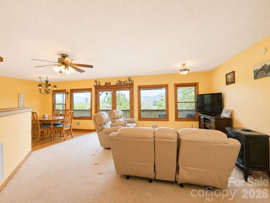 Wide-Open Mountain Views in Waynesville! Enjoy views from the covered deck and outdoor cooking area of this charming 2-bedroom, 2-bath home, built in 1993 and set in a peaceful country setting just 20 minutes from downtown Waynesville. This one-level home offers easy living, a spacious great room, a propane stove-style fireplace, a kitchen island, and large windows that fill the space with natural light and showcase the mountain scenery. Both bedrooms include private ensuite baths and walk-in closets. Step outside to the wraparound deck—perfect for relaxing or entertaining—with a covered outdoor cooking area ready for your grill and an outdoor portable gas fireplace. At 2,600+ ft elevation, this home enjoys cool mountain breezes and southeast-facing views ideal for sunsets. Additional features include ample parking for 2–3 cars, Zito internet/TV, city water, low annual HOA dues of just $120 (for road maintenance only). No city taxes and not within city limits. Short-term rentals are allowed.