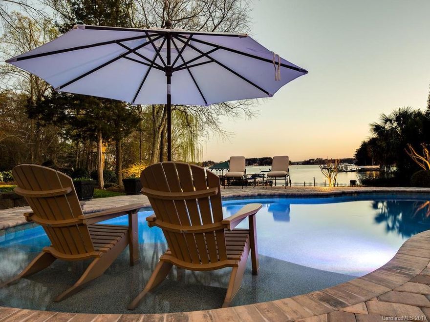Gorgeous Lake Norman sunset views from this classic cape cod waterfront home in the premier Peninsula. Elaborate lakeside entertaining features resort style salt water pool with Pebble Tec finish & sun deck, covered veranda with outdoor fireplace, al fresco dining and spa. Newly updated kitchen & refinished hardwood floors. Desirable open floorplan with main level master suite and upscale master bathroom. Four additional bedrooms, office area, loft & a cedar closet. Private pier with boat lift.