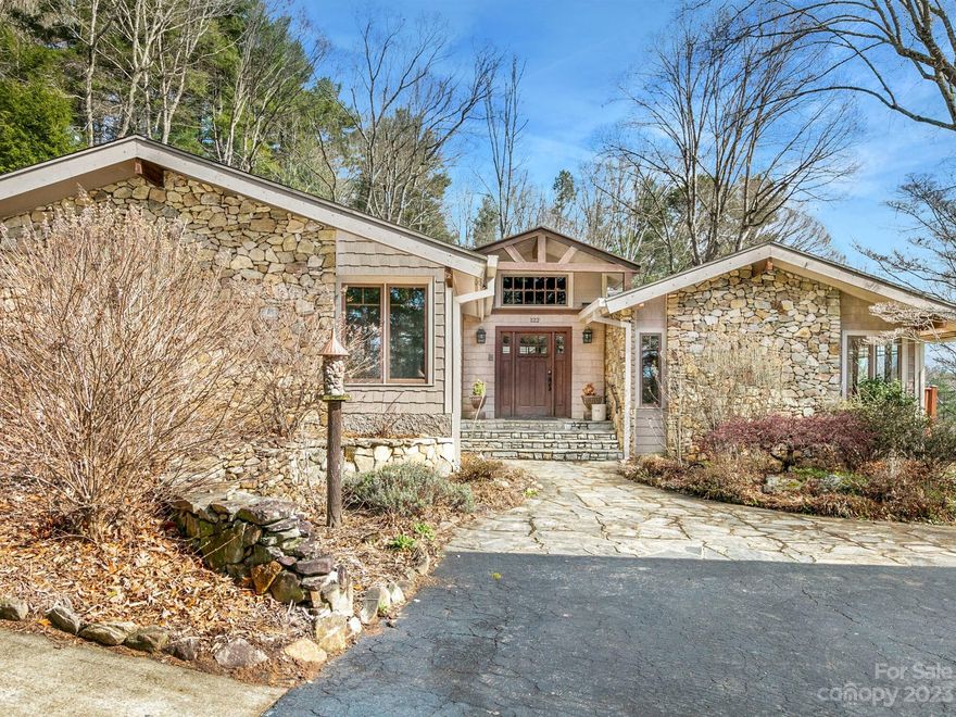 Beautiful mountain home w/ several unique opportunities - perfect live/work scenario, 2nd living quarter options, & 6 rare flat acres so close to Asheville! - Located in the Cane Creek Valley area, this lovingly maintained 5 BR home has 5890 SF of living area AND 1,640 SQFT of dedicated office space, making this the perfect property to operate a small business out of.  This home has tons of Arts & Craft character w/ custom stone walls/fireplaces, exposed wooden beams, & stain glass skylights. A finished basement w/ a full 2nd kitchen, 2 bedrooms, a family room & a rec. room could be more room for you or a 2nd living qtr. Beautiful outdoor spaces include a stone courtyard w/ outdoor kitchen & 2 decks. Soak in the distant mountain views while enjoying evenings relaxing around the firepit. The business space includes 6 offices, 2 reception areas, 1.5 baths, & separate parking area - it is possible to convert this to an apartment too. Detached 1car size workshop w/ 4 open bays onsite.
