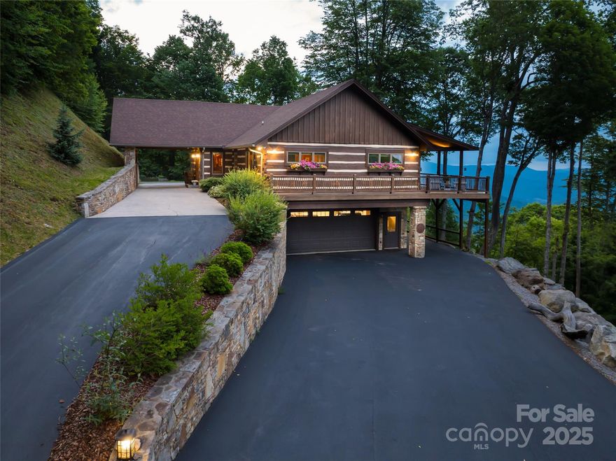 Welcome to a true log home where rustic charm meets refined craftsmanship, set in one of Maggie Valley’s most inspiring locations. With unrivaled, multi-layered views of Lake Junaluska & the Great Smoky Mountains, this property delivers an exceptional visual experience. Inside, you’ll find 3 well-appointed primary suites, each with custom cabinetry & finishes. The chef’s kitchen, featuring Wolf & Sub-Zero appliances and a walk-in pantry invites culinary prowess. This home was built for both beauty & function: vaulted ceilings, rich wood interiors,& expansive windows pair with practical features like a 2-car garage, elevator, a gently sloped driveway, & main-level entry under porte-cochère. Enjoy the benefits of a cooler climate, typically 5-10 degrees lower than the valley, & the security of a gated community with wide, paved roads. With easy access to Waynesville and Maggie Valley, this home is a remarkable find—perfectly positioned for those who appreciate both luxury & landscape.