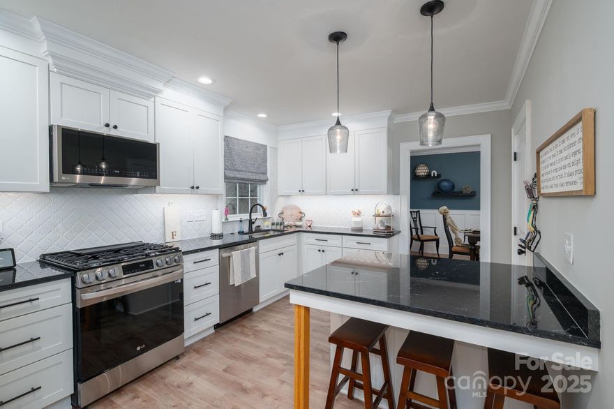 Completely remodeled brick home in historic downtown Newton! Renovation completed January 2023 with quality craftsmanship throughout. The beauty and character of this home were maintained with the brick exterior, original solid red oak hardwoods & the timeless front door. The interior was taken down to the studs and has new wiring, plumbing, fixtures, doors, & trim. Step into the spacious living room open on both sides featuring a beautiful fireplace with gas logs. The formal dining showcases original built-ins, board & batten Wainscoting and a separate entrance with a cozy brick porch. There is a large den with a wood-burning fireplace, detailed trim-work, a wet bar, and a Pella slider door that leads to a fabulous covered terrace for outdoor living enjoyment. The stunning kitchen features custom cabinets, quartz countertops, a decorative backsplash, a large island, under-cabinet lighting and LG appliances including a gas range. The main-level primary suite has walk-in and shoe closets plus a luxury bath featuring a floor-to-ceiling porcelain tile shower with a frameless door and porcelain tile flooring. A main-level laundry and half bath finish out the breathtaking main floor. Upstairs you will find 3 spacious bedrooms with walk-in closets and built-ins, plus 3 additional hall closets! The walk-out basement hosts a double garage, workshop and tons of storage. HVAC, water heater, roof, gutters, windows, exterior doors, garage door and walkways all replaced in 2022/2023. Re-coated driveway 2025. Extensive landscaping with established perennials & evergreens, LED landscape lighting and a backyard privacy hedge. See attachments for a complete list of all this home has to offer!