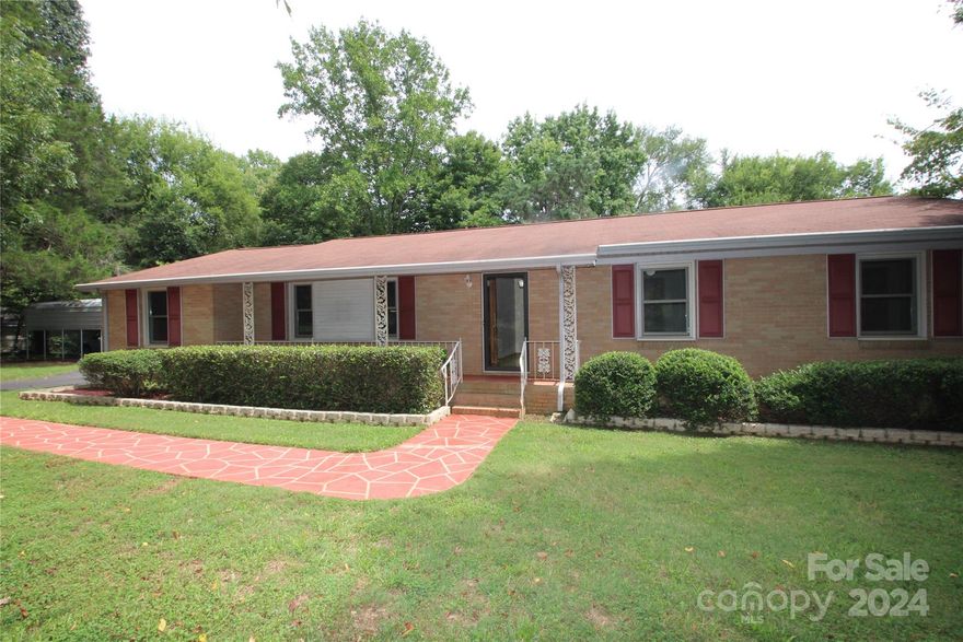 This is a one owner, full brick, home sitting on a private 1 acre lot.  The home has been well cared for, by the current owners, since it was built in 1963.  The original hardwood floors are in all three bedrooms, dining room and office. The Great Room and kitchen have laminate wood floors & both baths are tile.  The hallway bath has been completely updated and is handicap accessible along w/ 1 bedroom.  There is a large porch, currently it has a wheelchair ramp inside to provide cover.  In addition to a 2 car garage, 2 car carport, there is a third building w/ office, power & water. (35.5 x 17.5)  If you need handicap features, they are in place & for those not in need, they can be easily removed & returned to original. The completely fenced backyard has three outbuildings. (1)  tractor/lawn equipment shed 21.5 x 8.5.  (2) Storage building (10 x12) with power.  (3) Feed/chicken coupe building with electric and water.  This property also conveys frontage and dock on the community lake.