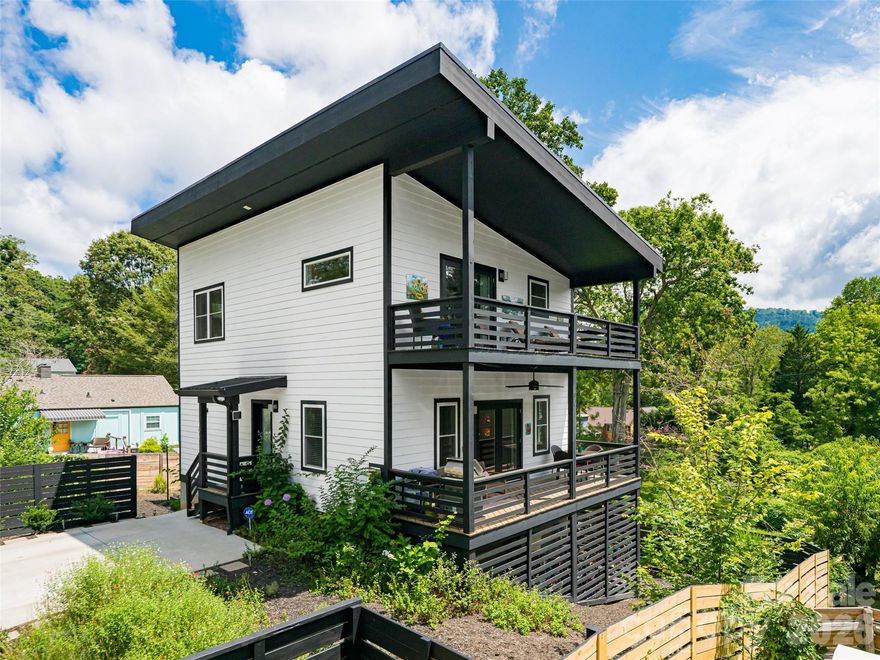 Beautifully designed and impeccably maintained, this contemporary 4-bedroom home in North Asheville offers the perfect blend of style, comfort, and convenience. Ideally situated within walking distance to UNCA, the Botanical Gardens, and the North Asheville Tailgate Market—and just 2 miles from downtown Asheville—this like-new 2022 build sits in a peaceful, established neighborhood. The striking black-and-white exterior with a sleek metal roof exudes modern sophistication. Inside, three levels of living space provide versatility, privacy, and plenty of room for gathering. Step outside to a flat, beautifully landscaped yard featuring a spacious patio, pergola, firepit, and raised garden beds—all framed by elegant black fencing. With no HOA dues, off-street parking for two, and a secure Mail Boss mailbox, this home truly has it all. Come experience it in person—you’ll be delighted!