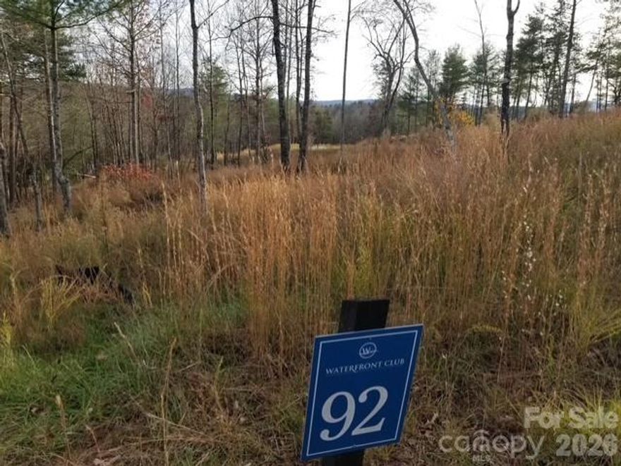 Experience refined waterfront living on Lot 92 Compass Court, a premier 1.34-acre homesite offering unmatched privacy, natural beauty, and direct shoreline access. Tucked gracefully at the end of a quiet cul-de-sac, this exceptional property features 80 feet of tranquil waterfront, creating an intimate connection to the water that is increasingly rare.
A canopy of mature hardwoods and lush native landscape frames the property, offering both seclusion and an exquisite backdrop for an architect-designed residence. Whether you envision a modern lake retreat or a timeless craftsman estate, this expansive homesite provides the ideal canvas for luxury living.
With limited waterfront opportunities remaining in the community, Lot 92 stands out as a unique blend of value, beauty, and exclusivity. Enjoy effortless access to kayaking, canoeing, and serene shoreline views — all from the privacy of your own wooded sanctuary.