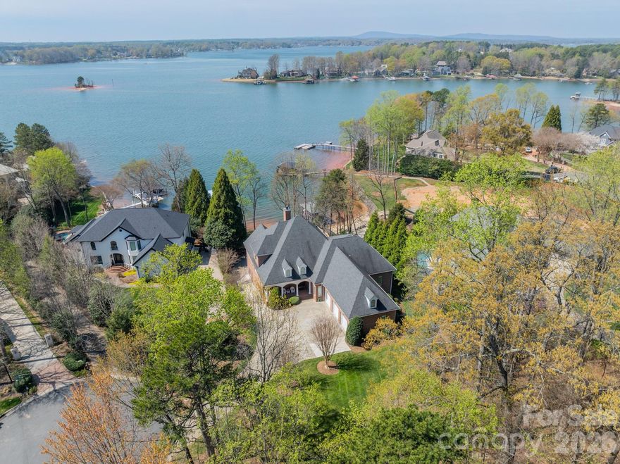 Welcome to a breathtaking home on a quiet cul-de-sac, overlooking Big Water on Lake Norman. This custom-built and designed home, nestled on three-quarters of an acre, is a dream come true. Inside, you'll find 3 levels offering 4 spacious bedrooms and 4.5 bathrooms. The open layout features a large living room connected to the spacious kitchen and breakfast area. Vaulted ceilings and large windows throughout the home offer an incredible water view. Head out onto any of the three patios for viewing or onto the screened-in porch for your morning coffee. The large primary suite features extensive windows that capture breathtaking lake views. The enormous finished basement is the perfect space for family and friends' entertainment. Be sure to check out the incredible storage space in your walk-in attic. You also have 2 additional garage spaces for autos or vehicles on the lake. Outside, enjoy your lovely landscaped yard and your extensive private covered dock, which includes a boat lift and jet ski float. Community amenities include a clubhouse, pool, tennis courts, and pickleball courts. This home offers a rare opportunity in one of Lake Norman's most coveted waterfront communities.