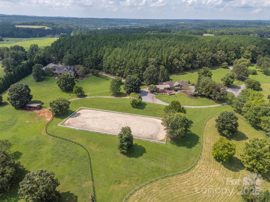 On the coveted CETA Trail System, Wellspring Farm spans 13.46 gently rolling, fenced acres with exceptional equestrian amenities and a beautifully crafted 4,591 sq ft home, designed so you can view the horses from nearly every room. The property includes multiple paddocks, a run-in shelter, a 100' x 240' riding ring, and a 63' x 39' center-aisle barn with six stalls, a wash stall, tack and feed rooms, and a garage. Above the barn is a charming 766-square-foot apartment, ideal for guests or staff. The home overlooks the pastures and arena with long-range views. Varied ceiling heights and a dramatic floor-to-ceiling stone fireplace define its open layout. The chef’s kitchen features premium appliances, and the expansive primary suite spans the western wing, opening to a covered verandah. The lower level offers two bedrooms, two baths, a family room, and an office/fitness space. A 2,250 sq ft workshop completes this refined, turnkey equestrian estate at the end of a private road.