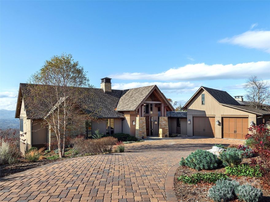 Mountain-modern custom home with Long Range Views.Foyer provides an immediate eye-catching view of the Blue Ridge Mountains & the French Broad River. Wood, stone and steel details throughout. The custom fireplace extends all the way to a vaulted ceiling, creating a focal point for the entire open plan living area. In addition, the retractable porch doors bring the outside in. This easy flow makes for exceptional entertaining. Custom kitchen was recently renovated & feels sleek and elegant. Island with hidden storage along seating side. Large Walk-in pantry. Dining Rm enjoys surrounding views & opens to the "View Porch" which boasts a kitchen, fireplace, ceiling mounted heaters for winter months & 3 levels of remote controlled screens. Primary Suite  HIS & HER closets, Walk-In Shower, Soaking Tub & Oversized Vanity. Lower level home theater, wine storage service and coffee bar. Home gym/office area w/ built-ins. 2 Suites & Covered Porch also on lower level. Heated and Cooled garage.