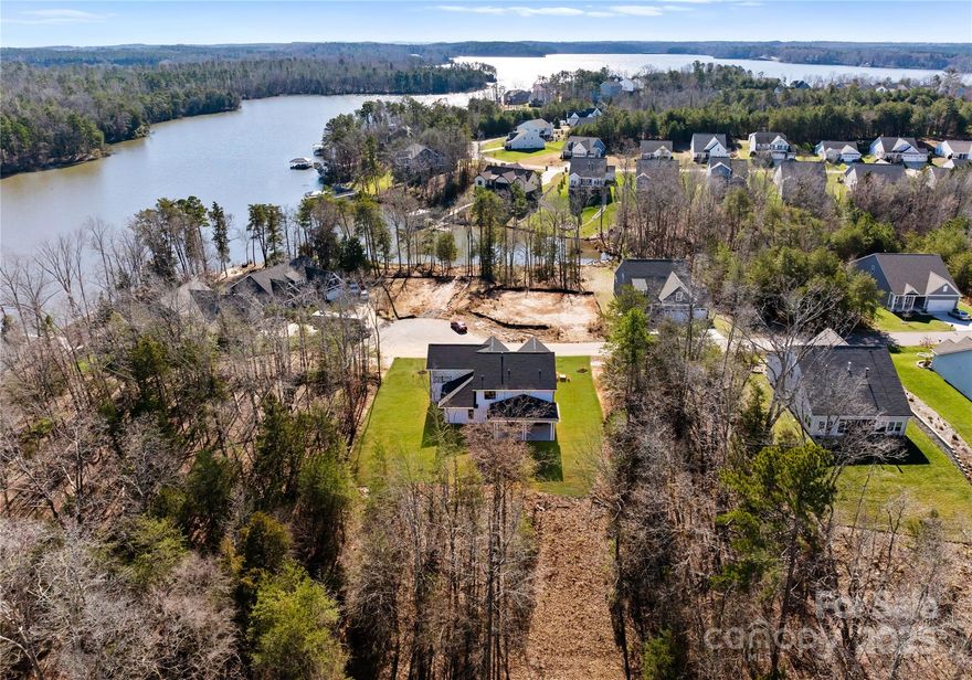 Experience luxury living in this custom-built 4-bedroom, 3.5-bath home in the prestigious Edgewater community. Spanning 2,888 sq ft, this residence boasts high-end finishes, including hardwood floors, quartz countertops, and a gourmet kitchen with a custom hood vent and double wall oven. The main-level primary suite offers a spa-like bathroom with a freestanding tub. Enjoy seamless indoor-outdoor living with a gas fireplace connecting the open-concept living area to the covered patio. Upstairs, a spacious covered area provides serene lake views. Edgewater residents relish resort-style amenities: a top-ranked golf course, lake access, walking trails, and an upcoming 19,000 sq ft amenity center featuring a restaurant, pickleball courts, and a Topgolf-style driving range. Embrace a lifestyle of elegance and recreation in this exceptional home.