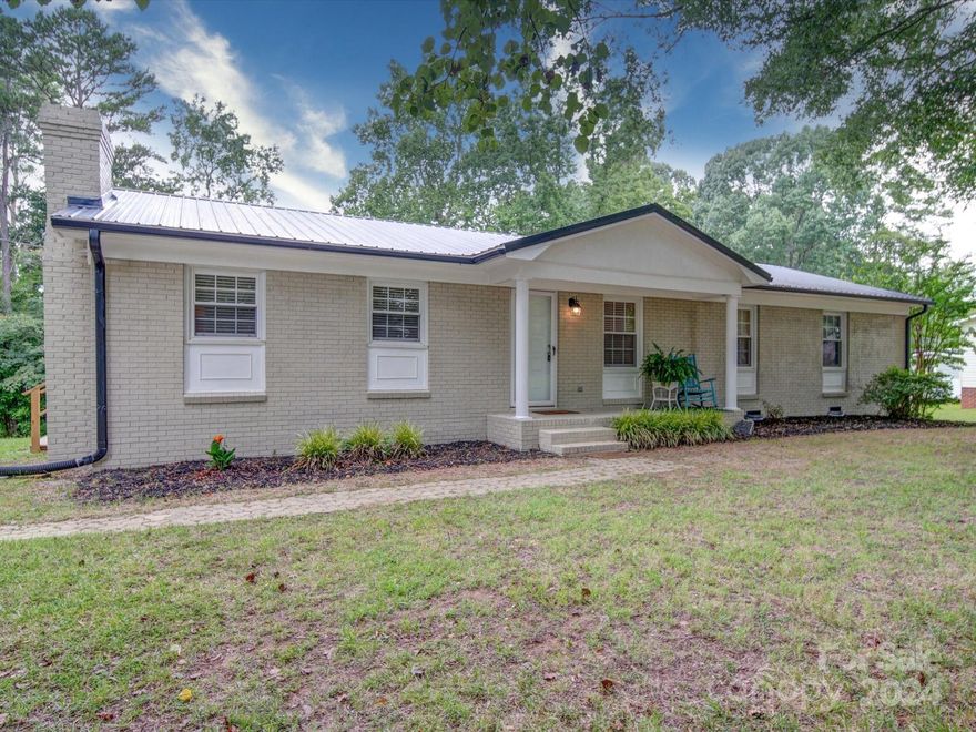 With over 1500 sqft, this full brick ranch has all the space you need! While minutes from I85, this 1/2 acre property is located on a peaceful and quiet street. Inside features an open layout, two options for entertaining rooms, and new flooring throughout. Metal roof installed in 2020. Picture yourself unwinding on your spacious deck, perfect for BBQs and lazy afternoons. The backyard offers ultimate privacy with a wall of trees, and you'll enjoy stunning sunsets right behind them. This home is ready for new owners!