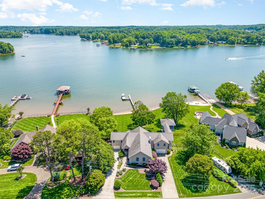 Welcome to paradise! This beautiful waterfront home with full walk-out basement is perfect for lakeside living. Whether you enjoy lounging on the expansive deck/patios, sunbathing on the beach, sitting by the firepit, or entertaining in the beautiful, cabana, you're sure to find the perfect spot. Be prepared to be wowed by the expansive water views. The large great room boasts a vaulted ceiling with gorgeous Brazilian Cherry Wood Floors.  Walk directly into gourmet kitchen, perfect for entertaining. Custom cabinetry, Granite, travertine floors, extra-large Kitchen Island, custom Dish-Pantry, Walk-in Pantry, and Laundry Room.  Covered Side porch off the kitchen has a raised covered Walkway leading to the awesome screened Cabana with sitting/dining/kitchen area and the best views!  In addition to the 4 Bed/4 Full Bath, 2 Half Baths, this home boasts 2 oversized 1-Car garages, 2-Driveways offering ample parking, PLUS an RV Pad w 220 outlet. Potential Short-Term Rental, No HOA & LOW taxes.