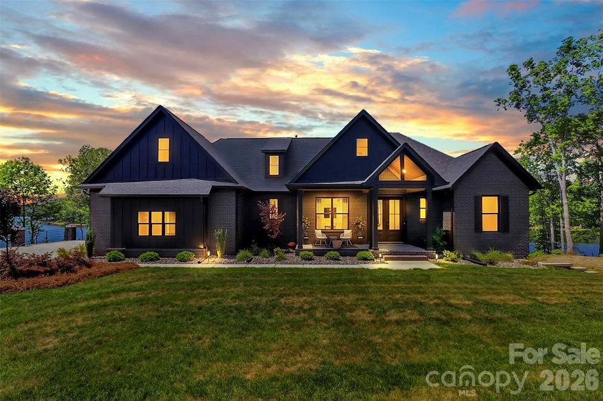 Extraordinary, custom-built lakefront estate ideally positioned on a premier homesite, showcasing breathtaking sunset views across the water. Thoughtfully designed from top to bottom with impeccable attention to detail, this residence is truly a must-see.
Step inside to an open-concept floor plan that flows effortlessly into expansive living spaces, perfectly suited for both everyday living and upscale entertaining. The chef’s kitchen is a true showpiece, featuring a panel-ready JennAir refrigerator, a 48-inch six-burner dual fuel range, double-drawer dishwasher, and an impressive 45-inch workstation sink. Calacatta Gold quartz countertops elevate the space, while a custom-designed pantry with butcher block countertops and a built-in beverage center adds both style and functionality.
Custom cabinetry is showcased throughout the entire home, complemented by a well-appointed dry bar with wine refrigerator and ice maker. An oversized laundry room offers exceptional storage and convenience.
The main-level primary suite serves as a private retreat, complete with serene lake views and a spa-inspired bath featuring an oversized dual-head shower and marble dual vanity. Generous his-and-hers closets provide ample space and organization.
The fully finished basement expands the home’s versatility, offering two luxurious bedroom suites, two full baths, a kitchen, dining area, and spacious family room—ideal for guests or multi-generational living. A flex room, currently used as a workout space, and abundant storage complete the lower level.
Throughout the home, 7-inch white oak flooring adds warmth and sophistication, while a whole-home water filtration system with reverse osmosis and a recirculating tankless water heater ensure modern comfort and efficiency.
Outdoors, experience a true resort-style oasis. A private, fenced-in pool is complemented by two covered porches, all framed by stunning lake views. Additional features include a 12x20 gazebo, putting green, and a custom outdoor kitchen equipped with a Blaze grill and griddle—perfect for entertaining year-round.
Located just off the 74 Bypass in an exclusive, privately gated community of only 12 homes, this exceptional property offers both privacy and convenience with an easy commute to Charlotte.
