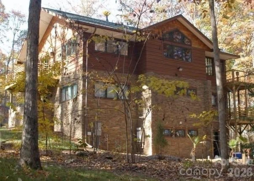 Architecturally distinctive and beautifully integrated into its wooded setting, this custom Davidson home offers a layout designed for buyers who value privacy, separation of space, and a one-of-a-kind living experience. Inspired by Frank Lloyd Wright and designed by architect Reed Tull, this is not a cookie-cutter floorplan. It is a home intentionally designed to live differently while taking full advantage of its natural surroundings. Tucked away on a cul-de-sac in the Pages Pond community, the setting adds even more privacy and charm.

The upper level is the heart of the home, where a dramatic wall of Kolbe windows frames the wooded backyard and fills the main living area with natural light. Here you will find the living room with Mendota gas fireplace and built-in Bose speakers, the kitchen with Wolf gas cooktop and Sub-Zero refrigerator, the laundry room, and the spacious primary suite with its own fireplace, heated bathroom floors, and a custom walk-in closet.

On the main level are two secondary bedrooms, a Jack and Jill bath, a bonus room, a dedicated office, and access to the oversized garage with two Tesla chargers and its own half bath. This level also includes a second refrigerator hookup, adding convenience and flexibility for everyday living, entertaining, or extended guest needs.

The finished walk-out basement adds even more versatility with a large recreation area, a full bath with claw foot tub, and a flex room that can serve as a workout space, additional office, sewing room, or hobby room. The basement bath is also plumbed for a stack washer and dryer, offering even more potential for multigenerational living, guest space, or future customization.

An Inclinator elevator connects all three levels, making the home easy to navigate while preserving its striking multi-level design. Additional features include two tankless water heaters, full home filtration, central vacuum, an invisible fence system, a newly painted exterior, dry under-deck system, custom copper chimney cap, and brand new European half-round gutters.

Set on more than an acre, Pages Pond offers over 27 acres of community green space, a 4-acre pond, tennis courts, and scenic walking trails. For the buyer seeking luxury, architectural character, and a layout that offers flexibility, privacy, and a truly distinctive living experience, this home is a rare opportunity.