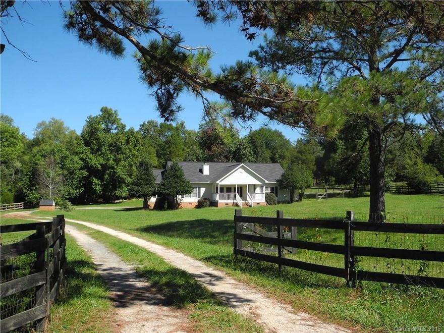 Almost 6 acs w/ large road frontage equestrian cross pastured w/ 5+ stalls. plus other rooms in barn/additional storage. Modified ranch (originally doublewide manufactured) with split 2 bedrooms and third/bonus room with built in shelves entertainment area.  Vaulted ceilings, open dining to living room.  Extra room (office or exercise room behind Master Bedroom and Laundry area. Front and Back porch that leads to attached patio and then storage and work room.  Beautiful Land  excellent location.