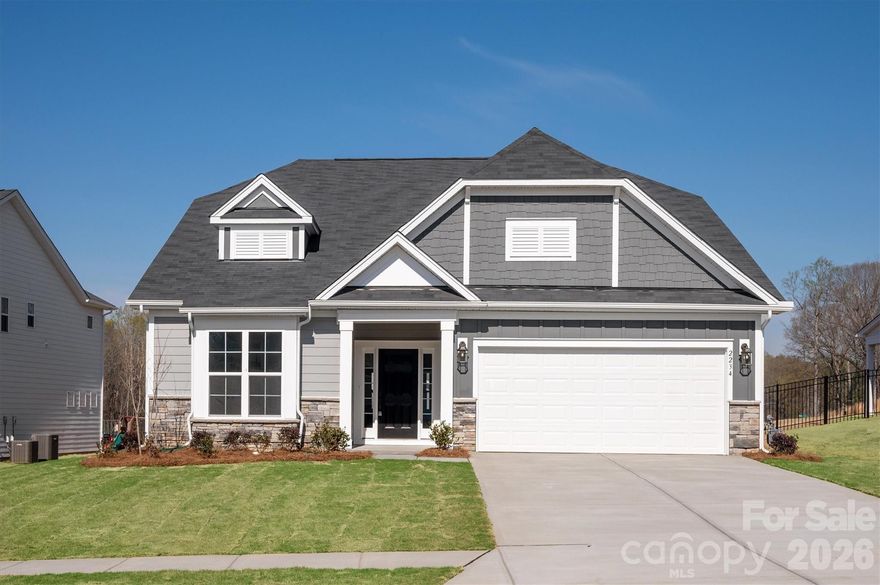 Enjoy first-floor living in this new 1.5-story home in Gastonia, with a blend of function, comfort, and style. The first floor has all the main living space, and upstairs is a spacious Rec Room, secondary bedroom and bath, plus unfinished storage space. Off the foyer is a guest bedroom and bath plus a Flex room. Beautiful, open-concept living with abundant windows for natural light; with the kitchen overlooking the dining area and family room. Kitchen features quartz counters, tile backsplash, GE stainless steel split cooking appliances with a 36" gas cooktop and extraction hood, with dark graphite-stained cabinets at the perimeter and white cabinets at the island. Off the kitchen is a Butler's Pantry which is great for entertaining, and a walk-in pantry. The Family room boasts a vaulted ceiling and gas fireplace with side niche. Enjoy the weather from the rear covered porch!  Premier Suite has a tray ceiling, walk-in closet, and bathroom with large tiled shower with semi-frameless glass, quartz counters, and 12x24" floor tiles. Full baths feature quartz counters and dark-stained cabinets. LVP flooring throughout most of the first floor, with oak treads on the stairs. The laundry room is tucked away off the mudroom, which features a built-in drop zone. Home includes energy-saving features of a tankless hot water heater and radiant barrier sheathing. Community pool and tot lot! Easy access to Uptown Charlotte and the airport.