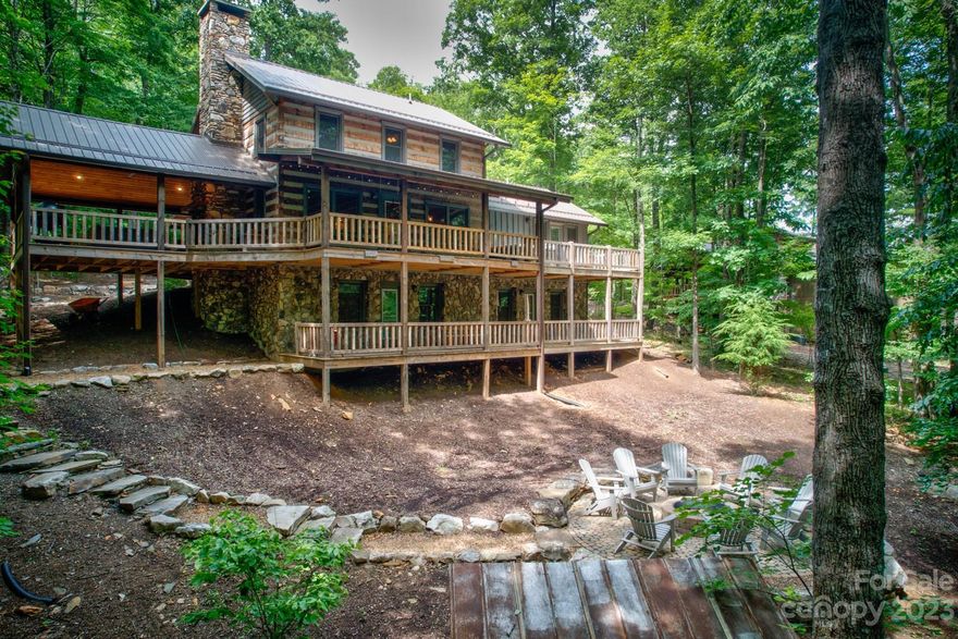 3BR/3BA LOG HOME! Great Room features vaulted ceilings, hardwood floors, hand-hewn logs and floor to ceiling wood-burning stone fireplace. Kitchen includes stainless appliances, granite countertops, large central island with breakfast bar and exposed beams. Primary bedroom, located on the main level, features access to the wrap-around deck and hot tub! Upstairs you will find an open loft bedroom and full bathroom. The lower level has a large family/game room with second stone fireplace (with gas logs), a spacious third bedroom and full bathroom. Outside you will find multiple outdoor living spaces including a large, covered outdoor entertaining area on the main level deck with outdoor fireplace and tons of room for seating! Multiple decks, open and covered, wrap around the home and the ones on the back side overlook the open back yard with a large firepit and stone walkway. Offered fully furnished (with a few exceptions) Great full time residence, vacation home or investment property!