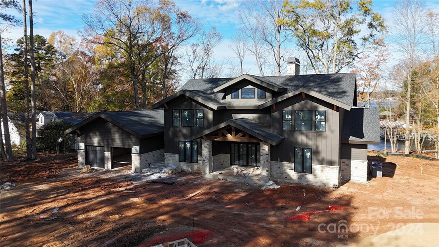 Experience unparalleled elegance in this stunning luxury lake home featuring an open floor plan that perfectly blends style and functionality.  1st level primary suite, offers a tranquil escape with an oversized shower, closet, and laundry area. The heart of the home boasts cathedral ceilings in the great room, 10’ ceilings on main level with 8' doors.  The custom-designed kitchen is a chef’s dream, 48” free-standing dual-fuel smart range with six sealed burners, double oven&under-counter microwave drawer, a quiet dishwasher, and a built-in side-by-side refrigerator/freezer, pantry with wine refrigerator. Highlights include black-on-black windows, quartz countertops. Upstairs features 3 Bedrooms/3Baths and loft. The oversized two-car garage leads to a pool house, and 1 of the outside to the covered living areas, complete with an outdoor kitchen—perfect for dining while overlooking the lake making this property a true oasis for relaxation and entertainment. Lot can accommodate a pool.