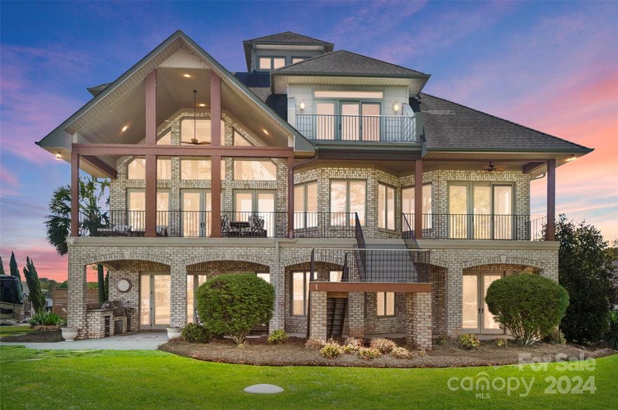 LIVE THE DREAM on Lake Wylie in this stunning 4BR CUSTOM home w/ spectacular main channel sunrise & sunset views! A showplace home designed for entertaining & luxurious lakeside living. Filled w/ natural light & custom touches: rich moldings, beautiful flooring, coffered & tray ceilings, arched doorways, & elevator! Grand foyer welcomes you to a 2-story great room w/ fireplace & built-ins flowing to Gourmet kitchen w/ss appliances, granite, island & dining area. Spacious primary suite boasts sitting area, 2 walk-in closets & spa-like bath. Loft, 2BRs each w/ BA on 2nd level. 3rd level provides viewing loft. Lower level perfect for 2nd living quarters & entertaining: Rec room w/ fireplace,  large bar, bedroom, & storage. Relax & live outdoors on the covered balcony, covered patio w/ outdoor kitchen, lakeside deck, or lounge in the hot tub w/ views! Enjoy boating adventures from your covered dock w/ lift & dual jet ski lift. Beautifully landscaped, LEVEL, yard. SC taxes & Clover schools.