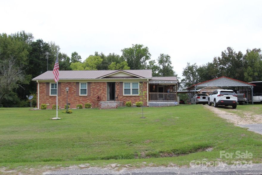 If you are looking for peace and quite look no further.  This home sits on approximately 3/4 of an acre.  Home is full brick with new heat pump, new line from county water meter to house, new well pump and tank if you prefer well water, new refrigerator, nice hardwood floors and plantation shutters.  Seller has updated plumbing from toilet to septic tank from cast iron to PVC as another improvement.  Move in ready with 3 bedrooms, 1 bath and a covered porch for entertaining.  Plus you have parking under a detached carport. Large storage building that is wired with window A/C.  This building has many possible uses and also has a concrete pad to one side that is covered for parking or entertainment.  Built-on storage area on the back of building for yard equipment.  This home has a lot to offer and is set up ready to go. Schedule a showing soon.