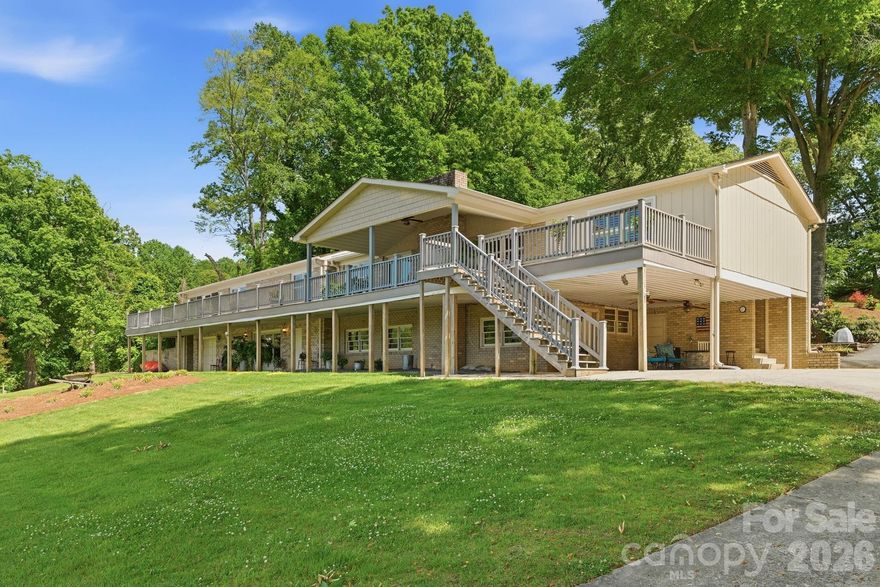 Enjoy the best of lake living in this beautifully designed waterfront home on Lake Norman, where thoughtful layout, expansive views, and exceptional outdoor amenities come together. The main level features a desirable split-bedroom design with a spacious primary suite and two additional bedrooms, each with its own ensuite bath and serene lake views. A light-filled living room with gas log fireplace opens to the well-appointed kitchen, complete with granite countertops, gray subway tile backsplash, custom cabinetry with pullout drawers, built-in pantry, wall oven and microwave, and smooth-top electric cooktop, all complemented by a casual breakfast area overlooking the water. A formal dining room with French doors, lake views, and flexible use potential adds even more versatility. The primary suite offers a generous walk-in closet and an accessible bath with easy-entry shower, bench, and grab bars. The lower level provides a fully equipped second living quarters with its own kitchen, living room, bedroom with ensuite bath and walk-in closet, laundry, and private access, ideal for extended stays or multi-purpose living. Additional spaces include a large workshop with full bath and a separate storage area with garage-style access, perfect for hobbies or lake gear. Outdoor living is truly exceptional, with a screened porch, covered patio, and an expansive wraparound deck designed to capture breathtaking views. The shoreline is enhanced by a long boardwalk, rare private boat ramp, and an impressive pier with gazebo leading to a stationary dock and two floating docks, including a covered slip with lift. Parking is abundant with an oversized side-load three-car garage, lower-level two-car carport, and circular drive. With no HOA and flexible-use potential, this property offers a unique opportunity to enjoy, share, or invest in a remarkable lakefront setting, all supported by thoughtful upgrades including a whole-house generator, water filtration system, multiple water heaters, and well-maintained mechanical systems. Home comes with 1-year warranty for peace of mind!