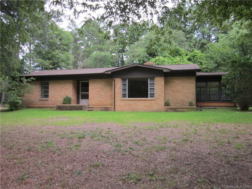 Charming 4BR/1.5BA brick home on +/- 1 acre lot at back of subdivision. Home features sunken living room with fireplace and parquet flooring, sunroom, large eat in kitchen, two bedroom share jack and jill half bathroom. There is attached 1 car garage with laundry connections in back area, 2 car carport with storage room for lawn equipment and two additional storage buildings located on property. There are three above ground oil tanks in back of home to fuel oil furnace located in cellar.