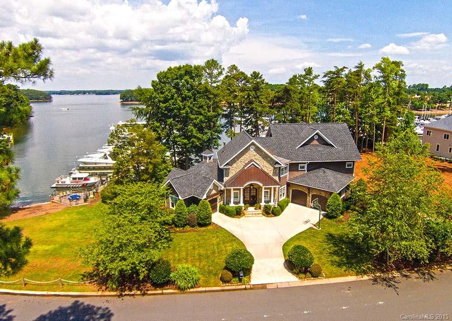 Inviting 2 story shake & river rock exterior. Steps to the lake from front or back of property. Custom molding, dining room w/built-in seating, walnut floors, stone fireplace/great room, large center island, 3 hammered copper sinks in kitchen/wet bar areas. Owners suite w/deck, vaulted ceiling, fireplace, bath/slate floors, separate vanities & soaking tub. 3 guest rooms+bonus room. Screen porch/fireplace, outdoor pond. Yacht Club dining & pool access is quick from boardwalk *boat slip included*