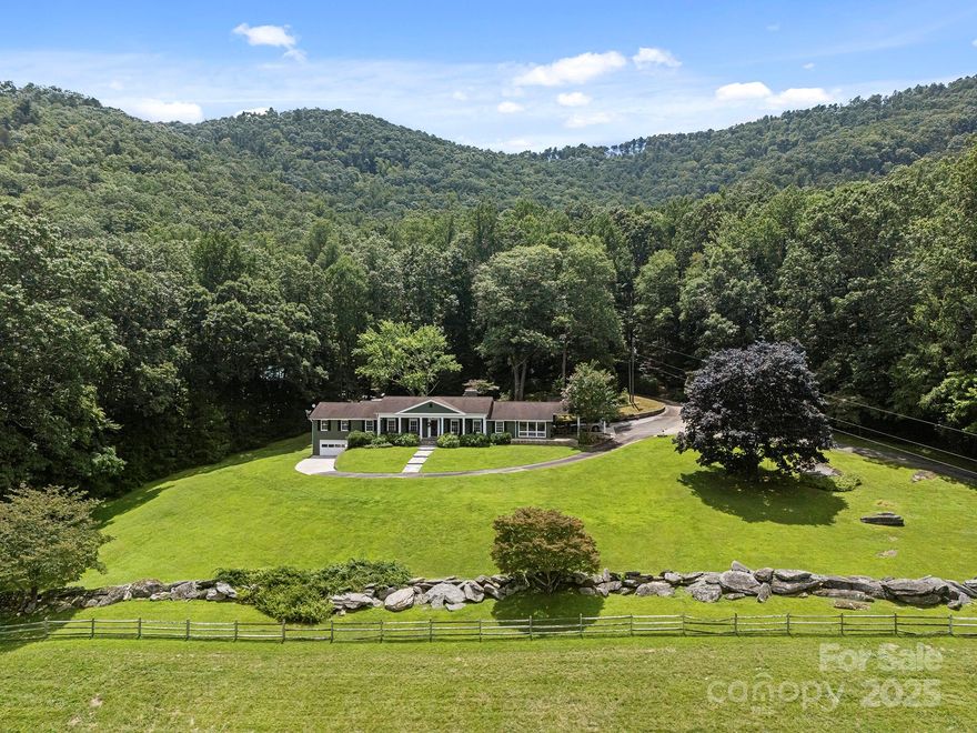 Now priced $150,000 less than current appraisal! Discover your own slice of paradise with this spectacular 33.6-acre estate. Perfectly positioned between Hendersonville and Asheville, this rare find blends lush open pasture with serene wooded privacy, a cascading stream & year-round mountain views. At the heart of the property is a well-appointed 3,290-square-foot residence which was taken down to the studs and remodeled in '04. For equestrians, the 7-stall barn is a dream, with its own well/ water heater, tack rm, hayloft & wash bay. A 2,400-SF climate-controlled Morton building is perfect for hobbies/workshop. Other outbuildings include a deluxe chicken coop, two run-ins, greenhouse & tractor shed. Recent updates to the property include a 3-zone HVAC system (2024), new septic system (2020), a basement drainage system with sump pump (2025), a 20kW generator, hot tub and solar gate. An adjoining 9.45-acre parcel is also available; inquire for details. Bring your horses and start living the farm lifestyle you’ve always dreamed of!
