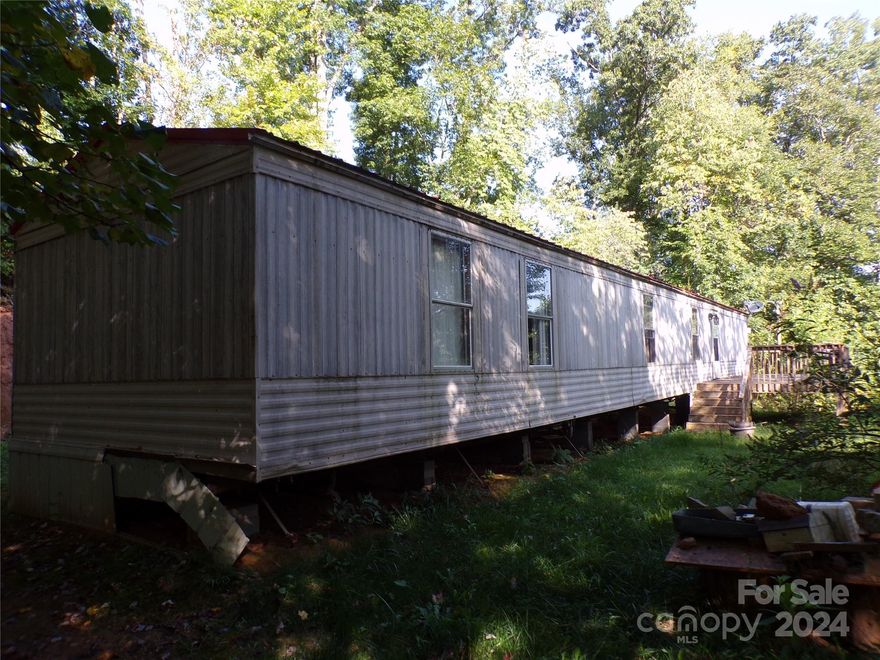 Singlewide mobile home only minutes from Historic and Quaint Downtown Canton. Flooring was replaced with  Luxury Vinyl Plank flooring throughout. Seller added a new metal roof a few years ago. Master bath is remodeled with a walk-in shower and 2 closets. Newer 10x28 Deck on front, view is limited, but some tree trimming might open it up. Home has a 3 bedroom septic is buyers wanted to add an additional bedroom. Driveway is very steep, and partly paved. 2 bedrooms, 2 baths. Most of underpinning and appliances have been removed by former tenant.  Show anytime. Bring all wheel drive or park at bottom and walk up to home. Power is off so bring a flashlight.  Showing time will give you combo box code. Present proof of funds with all offers please.
See attached survey and Deed showing Right of Way across Mayapple Lane from Howards Hollow.