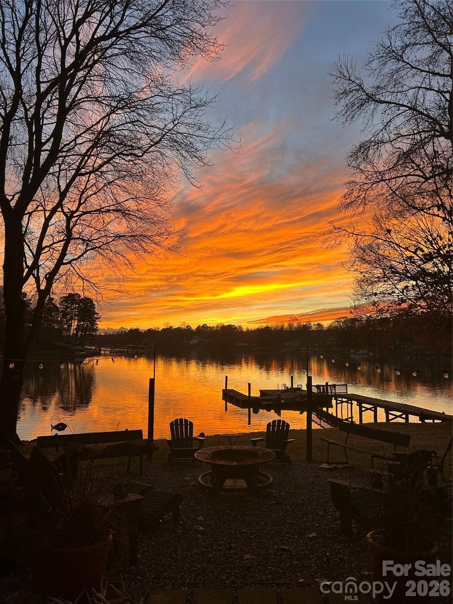 MULTI-MILLION DOLLAR LONG RANGE SUNSET VIEWS! NO HOA! Gently sloping lot to lake! Large circle drive! Stone steps to private sand beach area! Easy walk to your large private dock with boat slip! This charming beautifully decorated lakefront brick ranch comes with over 124 feet of deep-water frontage on LAKE NORMAN. Situated on a partially shaded ½+ acre lot in a quiet no-wake cove, this 3BR/2BA home offers DAILY breathtaking SUNSETS and tranquil outdoor living with a large screened porch, walk-out basement, covered patio, firepit area, hammock, and deck with space for a gazebo. Updated kitchen with stainless steel Viking refrigerator and KitchenAid appliances. Other features include a fireplace in living room and cozy den downstairs with woodstove, rec/office area in fully finished walkout basement with smaller second kitchen, laundry, and additional space ideal for guests or entertaining. Copy of single septic permit page doesn't contain bedroom count. Home is cooled w/ mini splits & Heated w/ mini splits & wall heaters. Preapproved buyers welcome!  Schedule your showing today!