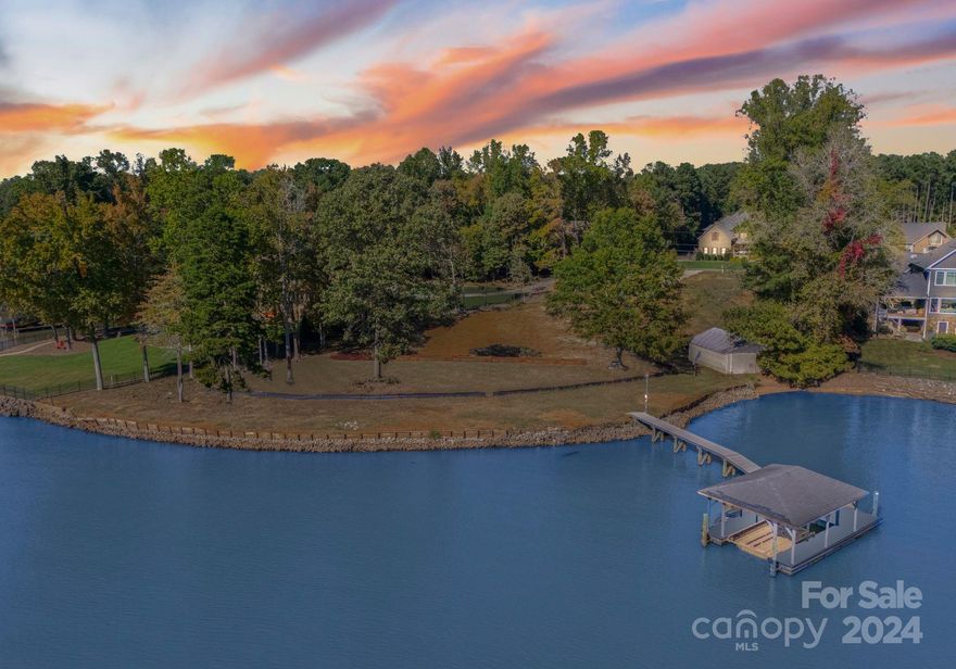 Nestled on the prestigious Brawley School Peninsula, this extraordinary 1.20-acre level lot offers 304 feet of pristine shoreline breathtaking Lake Norman views. This Southern Exposure lot has been cleared and includes architectural plans for a 6,663-square-foot home (not including the pool house), which will convey to the new owner. Featuring a recently rebuilt with Trex decking, covered Dock and a rare, grandfathered-in boathouse—offering the potential to be transformed into a charming pool house or Casita—this property is a true gem. A preliminary septic permit for a four-bedroom home has already been completed, allowing for a seamless building process. There is currently a three bedroom Septic Installed.  Located in a premier neighborhood surrounded by luxury residences and offering unparalleled lake access, this exclusive property is just minutes from Trump National Golf Club Charlotte and has the added benefit of no HOA.