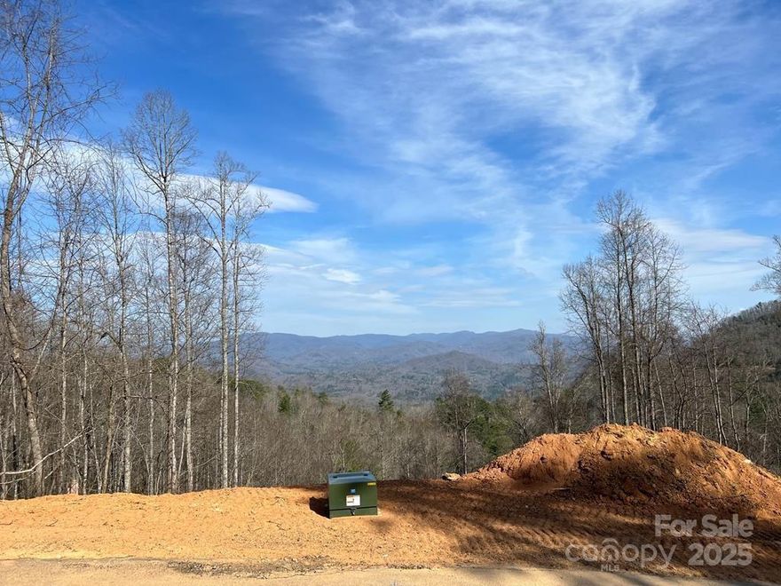 This undivided lot in Fontana View offers room for 2 home sites, one above the road & one below; both of which have AMAZING views of the Smoky Mtns Nat'l Park. You could sell off one portion of lot to help fund the construction of your new dream home on the other. Or build 2 homes, one to enjoy and one to rent. Or build a big garage/workshop/man cave. The upper portion of lot borders US Forest Service property, so your backyard will be acres of unspoiled wilderness. A driveway and house pad were excavated in 2022 on upper lot portion; 3 bedroom septic and well permits on file. This is a popular community offering year round access right off 4 lane highway 28 in Almond. Fontana View Properties is a very well maintained and excellent neighborhood to live in with very successful vacation rentals PLUS many year round residents. Just a few minutes from Fontana Lake, Almond Boat Dock & Marina, Bryson City, the Great Smoky Mountains Nat'l Park, rafting in Nantahala Gorge, the Dragon's Tail and Harrah's Casino in Cherokee. This lot is ready to build!