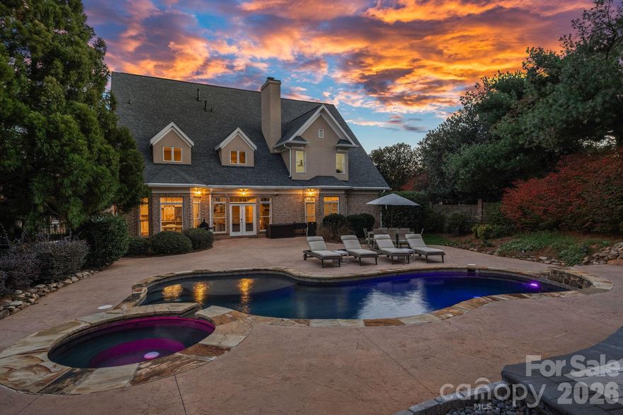 Just a golf cart ride from The Peninsula Club and Safe Harbor Yacht Club, this all-brick home is located in The Peninsula, one of Lake Norman’s most sought-after golf course communities offering resort-style amenities.
The true standout is the private backyard oasis, featuring a heated saltwater pool and spa, expansive sun deck, and a large pergola with a solar roof that offsets approximately 50% of the home’s power usage, ideal for both entertaining and everyday enjoyment. Inside, the main level offers a bright, open floor plan with vaulted ceilings and abundant natural light. The gourmet kitchen is equipped with a large island, double wall ovens, a butler’s pantry, and a breakfast area that flows seamlessly into the main living space. Additional main-level highlights include a formal dining room, a vaulted office, and a luxurious main level primary suite with bay windows, hardwood floors, spa-style bath, garden tub, large shower, and dual walk-in closets. Upstairs, you’ll find three en-suite bedrooms, a bonus room, and a second office, providing exceptional flexibility. Dual bonus spaces offer the option for a 5th bedroom if desired. A three-car garage provides excellent storage for vehicles, golf carts, and lake gear. Additional updates include a new roof in 2024. This home combines comfort, efficiency, and an unbeatable Peninsula lifestyle.