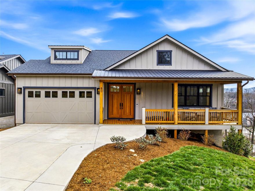 Modern mountain luxury meets timeless neighborhood charm in Kenilworth. Just south of downtown Asheville, this striking hillside residence overlooks Biltmore Village and captures coveted eastern mountain views—perfect for greeting the sunrise from either of the two expansive rear decks.

Built in 2023, the home was thoughtfully designed with luxury at every turn, from Viking appliances and whole-home Sonos audio to the wet bar, copper gutters, and dramatic folding glass wall that seamlessly blends indoor and outdoor living. Hardwood floors span most of the main level, leading into a stunning open-concept living, dining, and kitchen space highlighted by soaring ceilings and lots of windows that flood the home with natural light.

The chef’s kitchen is as beautiful as it is functional, featuring a 6-burner Viking gas range with hood, granite countertops, and a showstopping custom end-grain walnut island top. The dining area flows from the breakfast bar into the living room, where a gas fireplace creates warmth and ambiance. Sliding glass doors open to the rear porch, complete with a built-in natural gas grill line—ideal for entertaining while taking in the serene mountain backdrop.

The main-level primary suite is a true retreat, offering two walk-in closets, a spa-inspired ensuite bath, and direct access to the rear porch through glass sliders. The bath features tile flooring, leathered granite counters, a makeup station, and a glass-enclosed shower with both rain-style and handheld showerheads. An additional bedroom with a Jack-and-Jill full bath, along with a two-car garage, completes the main level.

Downstairs, the luxe lifestyle continues. Enter the expansive family room through French doors and unwind with Hunter Douglas blinds, Sonos surround sound, and a fully equipped wet bar featuring a beverage fridge, ice maker, bar sink, and generous shelving. The true showpiece, however, is the wall of folding glass doors that opens completely to the lower screened porch—an extraordinary indoor-outdoor living experience.

The lower level also includes a second primary suite with ensuite bath, walk-in closet, and porch access, a fourth bedroom, a full hall bath, a laundry room with utility sink, and a large flex space beneath the garage—perfect for a home gym, theater, storage, or hobby room. An on-demand gas water heater ensures continuous hot water, while tile flooring in all bathrooms and luxury vinyl plank on the lower level add durability and style.

While the rear porches may tempt you to stay home all day, Biltmore Village and downtown Asheville are just minutes away, offering world-class dining, shopping, and culture whenever you’re ready to venture out.