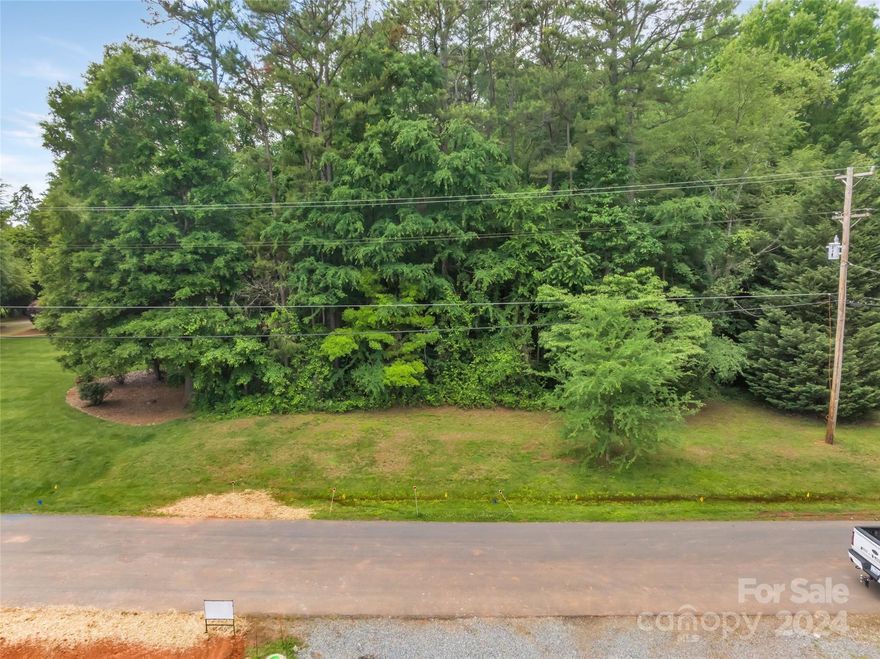 WATER VIEWS & LAKE ACCESS!!! LOCATION, LOCATION, LOCATION!! THIS IS IT!!!!  Come build your own home or the seller, a custom home builder, can build it for you.  Just under 1/2 acre lot on paved street in Huntersville, 3.8 miles from exit 25 on I-77, 2.7 miles to Birkdale Shopping Center! This lot has LAKE ACCESS and it's own "recreational area" with a beach, picnic table and water access. See attachments for handwritten restrictions from 1964. Water & sewer available with payment of tap fees. For well/septic, perc test was done in 2006, but can be renewed. Only the original 10 lots on this street have the water access, and the cul-de-sac ended at the recreation lot (Lot #16). See attached map. Since then, the cul-de-sac has been extended and high-end homes are being built up and down Henry Lane. Here's the perfect opportunity to build your dream home on a wooded lot with water views and lake access! The location is very convenient to pretty much everything you need in your daily life.
