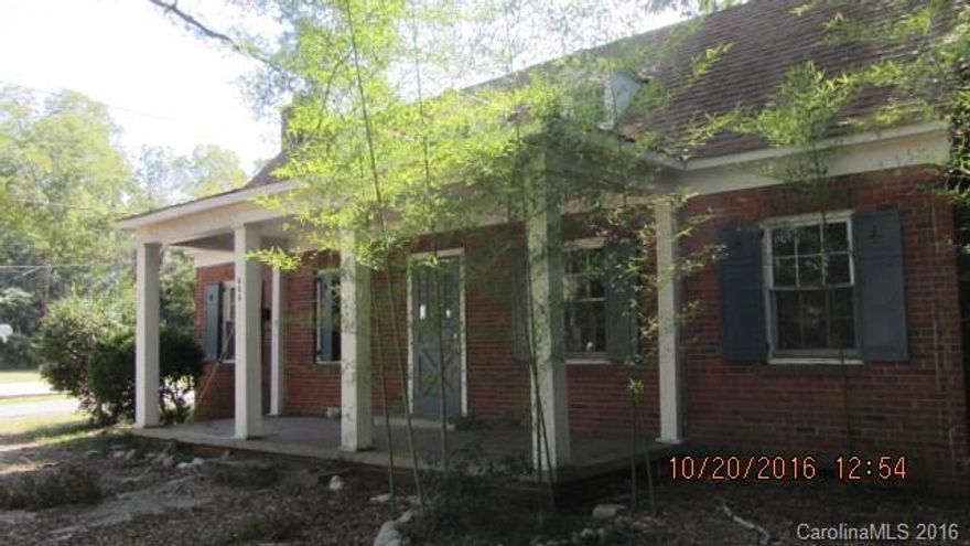 Great potential!!! Large brick ranch with rocking chair covered front porch. Rec-room addition on the back.  Deep corner lot. House sits on the back of the lot.  Small basement area with inside access. Hardwood and laminate floors.  Large dining room with built-ins.  This can be a beautiful house.