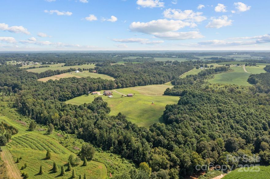 Discover the perfect blend of comfort, privacy, and functionality on this 46.84-acre North Iredell estate  - affectionately named “Ridgetop”. Tucked away from the road, this 5-bedroom, 4-bath home offers scenic views, wooded trails, abundant wildlife, and a creek running through the property.

Ideally suited as a private equestrian estate, hobby farm, or boarding/training center, the property features a 4-stall center-aisle barn built in 2020 by Ever Trust Construction LLC with matted stalls, insulated tack room with A/C, hay storage, outside wash station, fans, and two frost-free pumps. The property includes a 7+/-  acre pasture with a combination of 4-strand electric + post and rail fencing, plus an additional 1.5–2 acre pasture with 3-strand electric fencing. A service road provides easy access to the barn.

The main home showcases hardwood floors, ceramic tile, crown molding, chair rail detailing, recessed lighting, and expansive windows that frame the pasture views and panoramic countryside. Primary bedroom has tray ceiling, beautiful bath and huge walk in closet. 3 bedrooms upstairs with Jack & Jill bath. A second living quarters in the basement includes a full kitchen, ideal for multigenerational living, guests, or rental opportunities.

Outdoor living is a highlight with a spacious deck, screened porch, and a covered walk-out patio for entertaining or relaxing and a heated 16' x 38' Figerglass Ionizer Pool with travertine pool surround, 6' 3" at deep end with sunshelf (new pump 2024).

Outbuildings include a 1200 sq ft workshop with water, electric, and wood stove plus a 24' x 24' open shed for storing equipment.

This property combines the best of country living with modern convenience—ready to support equestrian pursuits, farming, or simply enjoying a private retreat surrounded by nature. Located in Northern Iredell and convenient to major interstates 77 and 40.