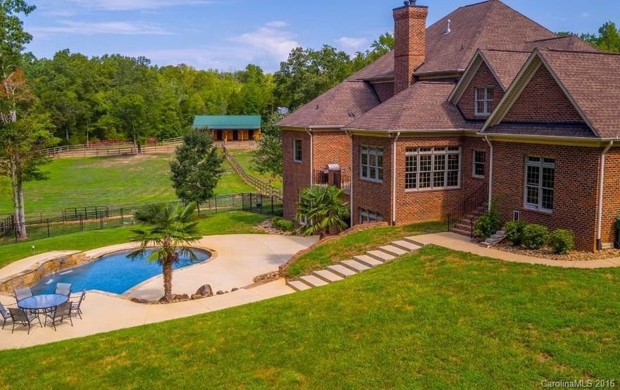 This premium country estate is located in the charming village of Waxhaw & part of an exclusive community w/riding trails. Manicured, private acres w/gated entrance, custom built brick home w/quality details throughout including extensive trim work, built-ins, custom cabinets, SS appliances, granite, HW & tile floors. Basement w/same quality as first 2 floors & ideal for relaxed living or 2nd living qtrs. Outdoor living at its best w/an in-ground pool, board fenced pastures & 3 stall show barn.