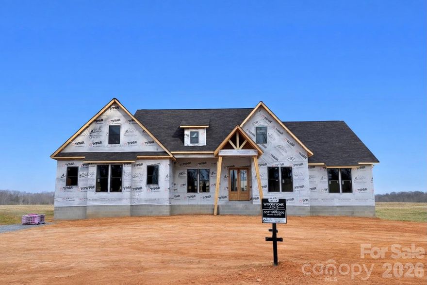 Luxury Custom Farmhouse Spec in Woodstone Communities newest subdivision, Woodstone Acres, with no HOA set to be completed 4/17/2026. This beautiful new construction is set on a huge 1.53-acre lot. The Cottonwood model is a sprawling 1-Story ranch offering approximately 2,980 sq ft with 4 bedrooms, office/study, all designed with upscale finishes and a thoughtful layout including 11’ ceilings in the main living areas. This model also includes a 16-speaker stereo system. The open chef’s kitchen features custom cabinetry, upgraded quartz countertops throughout, gourmet Forno gas range and appliances. This all opens to your living room area that features a gas fireplace and a 12’ sliding patio door leading to your huge covered porch with Trex decking allowing for indoor/outdoor entertainment. The primary suite offers a huge bedroom, spacious walk-in closet with custom built-ins and dresser drawers, and a spa-inspired bath with soaking tub and custom tile work. Additional highlights include beautiful engineered hardwood, tile and carpet flooring, custom wood shelving throughout, abundant storage, and unfinished upstairs bonus room with rough-in electrical, plumbing and HVAC ready for future addition. Exterior features Hardie siding with beautiful M-Rock stone and brick accents for lasting curb appeal and a sealed crawlspace foundation equipped with a dehumidifier. This is a great opportunity to get in early at the beautiful Woodstone Acres.