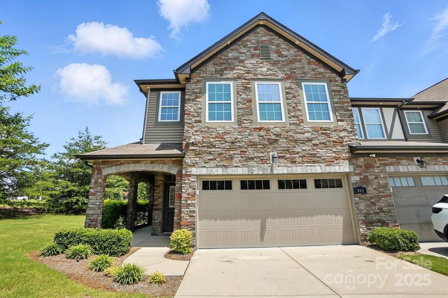 Luxuriously updated and impeccably maintained, this end-unit townhome offers upscale living in a prime location. Once a model home, it showcases a striking brick and stone exterior with sun-drenched interiors. Designer touches include wide-plank engineered hardwoods, fresh paint, elegant lighting, and a reimagined entry with detailed moldings. The chef’s kitchen features granite counters, glass-front cabinetry, under-cabinet lighting, a large island, and a new stainless refrigerator. The great room centers around a custom fireplace with a handcrafted mantle. Upstairs, a spacious primary suite is joined by two additional bedrooms and a custom-outfitted laundry w newer washer and dryer included. Enjoy a finished two-car garage with built-in storage, plus a private rear patio perfect for relaxing outdoors. Every space reflects thoughtful upgrades and timeless appeal. Fort Mill Schools, close to everything. Move-in ready and styled for modern living—this is townhome living at its finest.