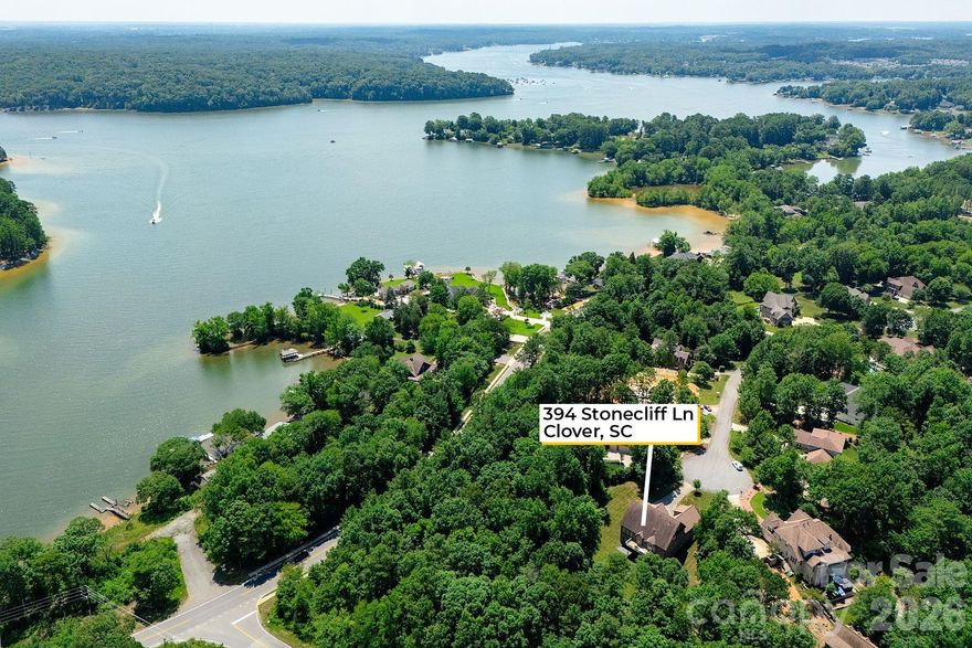 PRICE UPDATED! The FULLY FINISHED WALK OUT BASEMENT is a standout feature, perfect for a private guest suite, multigenerational living, or a comfortable mother-in-law retreat. It includes a private office with elegant French doors, a stylish wet bar with granite countertops, a spacious recreation room with an electric fireplace, a dedicated exercise room, a large bedroom, a full bath, and additional laundry hookups. Gourmet kitchen that is truly the heart of the home. It boasts gleaming quartz countertops, tile backsplash, newer appliances, and a walk-in pantry that offers ample storage. Adjacent to the kitchen is a cozy keeping room with custom built-in cabinetry. The sunny breakfast nook features a charming built-in bench seat and offers a beautiful seasonal lake view, making every morning feel like a retreat. The main-level primary suite showcases double tray ceiling, a spa-inspired en-suite bathroom with quartz countertops, garden tub, separate shower, and custom closet shelving. Spacious secondary bedrooms, including one with its own private en-suite bath—perfect for guests. A massive bonus room provides versatile space that could easily be converted into a home theater, media room, or play area. This home grants access to award-winning Clover schools. Zoned for NEW LAKE WYLIE HIGH SCHOOL! A Marina, Boat Storage and Restaurant just a few miles away. Stunning designer home located in a quiet cul-de-sac.
