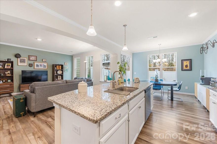 7018 Heron Rookery Way has it all: peaceful wooded views, a private fenced yard, and neighborhood access to Lake Wylie, plus a comfortable and bright interior with sleek finishes and abundant storage. The open concept main living area features 9' tall ceilings and tons of natural light. A wide archway frames the kitchen with a large island, granite countertops, stainless appliances, and a revamped pantry. The adjacent dining area provides ample seating and leads to the backyard oasis with a privacy fence and added paver patio. The main level bedroom makes a great office or flex space. Upstairs, the generous primary suite features an oversized shower, double vanity, and the closet of your dreams. The laundry room conveniently connects to both the primary closet and the common hallway. Two additional nicely-sized bedrooms, a full bathroom, and a large landing/loft complete the upper level. Ideally situated within the community, this townhome provides unbeatable peace and privacy. The Vineyards offers fantastic amenities like lake access, two pools, pickleball courts, and more. Welcome home!