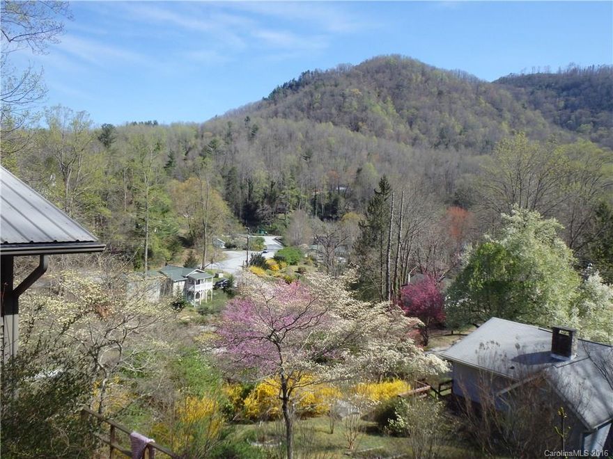 Sit on your deck and watch and listen to the river roll by. Watch the sun rise over the community of Bat Cave, NC. Inside, sit by your wood stove, relax and enjoy this year-round home that is maintenance-free due to vinyl siding and metal roof. The full basement has a full bath and two entrances.