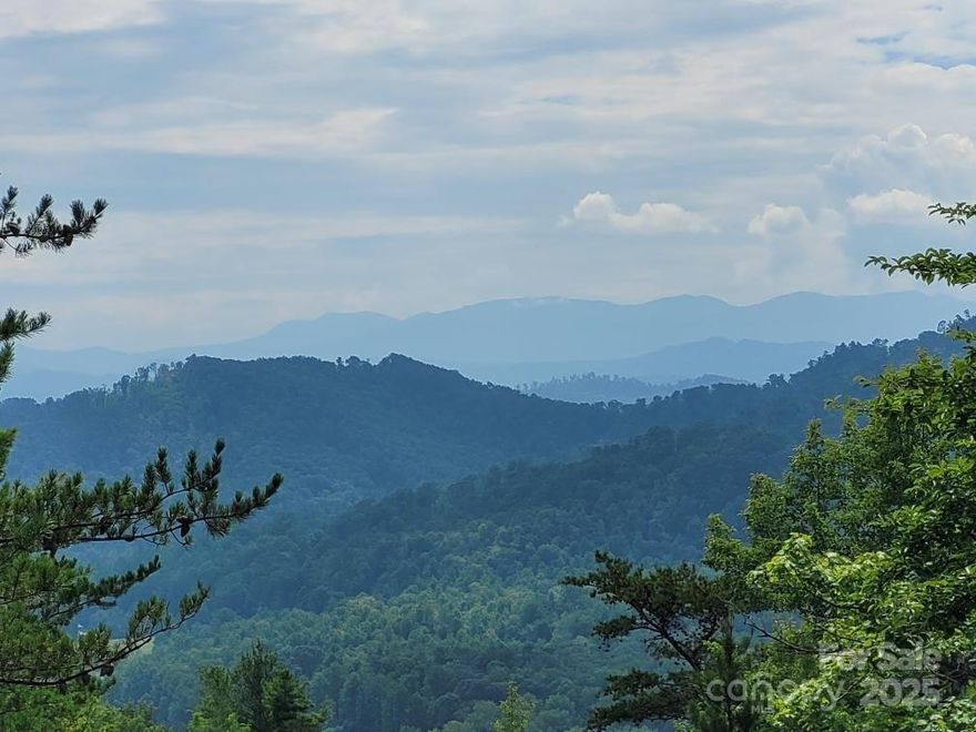 Stunning long range mountain views with the soothing sounds of Pond Branch Creek!! Nearly 7 acres with a level build site that has year round views of the iconic Black Mountains, the highest elevations in the eastern United States. Trim a few more trees and you'll have sweeping mountain views. This property features two water sources, including frontage along Pond Branch Creek and an installed well. With the potential to accommodate up to four homes, it’s perfect for a private estate or investment opportunity. Set within the quiet, Oconee Falls gated community, this parcel offers both seclusion and convenience. A rare gem priced to sell, don't miss your chance to build in one of Western North Carolina’s most scenic regions.
Located just 10 minutes from Linville Falls, the Blue Ridge Parkway, and Linville Falls Winery, 40 minutes to ski resorts, and 50 minutes to Boone.
