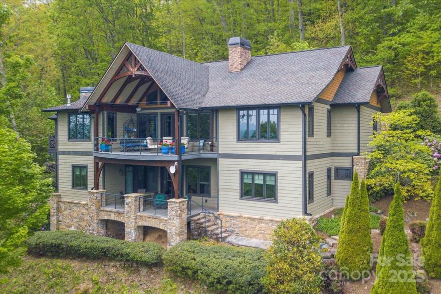 Experience the perfect blend of craftsmanship and comfort in this striking post-and-beam home, offering soaring ceilings and breathtaking year-round mountain views. The expansive Great Room unifies the dining area, living room, den, and chef's kitchen into one dynamic space, anchored by a stunning stone gas fireplace and rich knotty alder finishes. The kitchen is a dream for culinary enthusiasts, featuring all Thermidor appliances, including a 6-burner gas cooktop with grill, extensive custom cabinetry, a wet bar, and a walk-in pantry. Step outside to the attached gazebo with pellet grill and covered deck. The lower level opens to another covered deck and includes two ensuite bedrooms, a family room with fireplace, a wine room, and a separate entrance with private parking. Upstairs, you'll find a versatile 600 square foot room with a full bath and steam shower, ideal for an office, gym, or artist's studio. This home is a rare combination of luxury, warmth, and functionality.