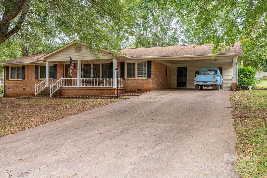 This charming ranch-style home features a full brick exterior that exudes classic appeal and durability. Upon entering, you'll appreciate the open floor plan that seamlessly connects the living spaces, making it ideal for entertaining and family gatherings. The rich hardwood flooring flows throughout, adding warmth and elegance to the interior.

The spacious living area includes a cozy brick fireplace, perfect for chilly evenings. The large kitchen is a standout feature, boasting ample cabinet space for all your culinary needs, along with appliances that make meal prep a breeze. 

With three well-appointed bedrooms and two and a half baths, the home offers plenty of space for family and guests. The two distinct living areas provide flexibility, whether you want a formal sitting room or a casual hangout space.

Step outside to enjoy the covered back porch, a perfect spot for outdoor dining or relaxing with a book. The property also includes two storage sheds and a workshop attached to the carport, offering additional space for hobbies, tools, or outdoor equipment. This ranch home combines comfort, functionality, and charming outdoor features, making it an ideal retreat for any lifestyle.