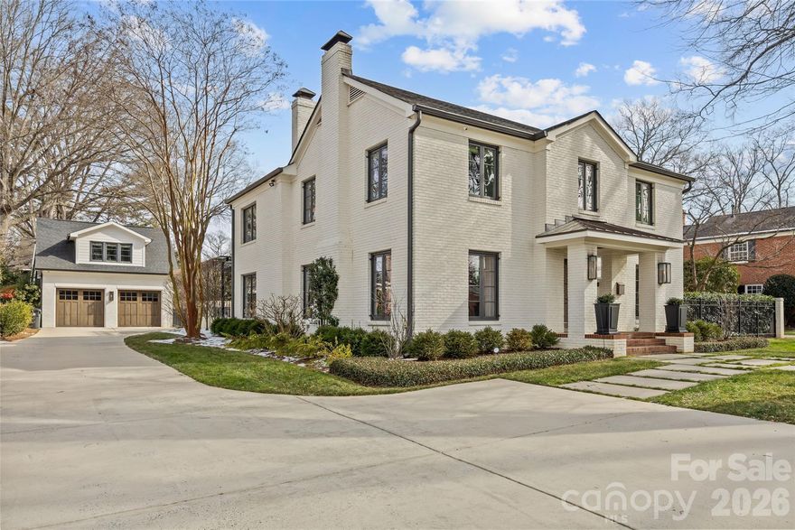 There are few addresses in Charlotte that carry the weight of Queens Road West, and fewer still that have been elevated to this standard. This stately Myers Park residence represents a ground-up transformation, where classic architecture meets modern precision on one of the city's most prestigious streets.

Beyond the brick façade lies a home rebuilt for the way discerning buyers live today. The kitchen anchors the main level with marble surfaces stretching across a generous island, professional-caliber appliances including a six-burner gas range with dual ovens, paired dishwashers, and separate refrigeration and freezer columns. A farm sink and secondary prep sink with filtered water handle the demands of serious cooking, while the adjacent butler's pantry—outfitted with wine storage and an ice maker—ensures seamless entertaining.

The main level flows with intention: a gracious living room, formal dining, office, great room, and breakfast area all connect while maintaining distinct purpose. Upstairs, five bedrooms include a primary suite designed as a true retreat with generous proportions, abundant natural light, a fireplace for cooler evenings, and a spa-caliber bath featuring a freestanding tub, marble shower with triple shower heads, double vanity, and private washroom.

Five fireplaces punctuate the home, including one on the covered bluestone terrace where outdoor living extends well into the evening hours. A metal pergola overhead, landscape lighting throughout, and a fully fenced yard create an entertainer's backdrop rarely found at this scale.

Practical considerations have been addressed with equal care: a whole-home generator provides peace of mind, laundry facilities serve both floors, and a walk-up attic offers future flexibility. Above the detached two-car garage, a complete guest suite with bedroom, full bath, and living space provides options for visitors, staff, or home office needs.

The grounds span nearly half an acre with mature trees, in-ground irrigation, and infrastructure in place should a future pool be desired.

Located within an easy walk of Myers Park Country Club, Freedom Park, and the boutiques and dining along Selwyn Avenue, this is a rare opportunity to own one of Charlotte's truly significant properties—reimagined for the next generation.