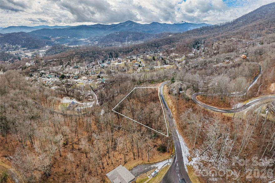 Excellent opportunity for seeking a mountain community with infrastructure already in place. This 1.13-acre lot is located in the gated Mountain Watch at Brannon Forest, featuring paved roads, underground utilities, and year-round access. Wooded setting with mountain views at over 3,000 feet elevation creates an ideal backdrop for a custom home. Site-built construction only (minimum 1,200 sq ft). Short-term rentals permitted. Close to the Blue Ridge Parkway, Asheville, Waynesville, Lake Junaluska, and Cataloochee Ski Area.
