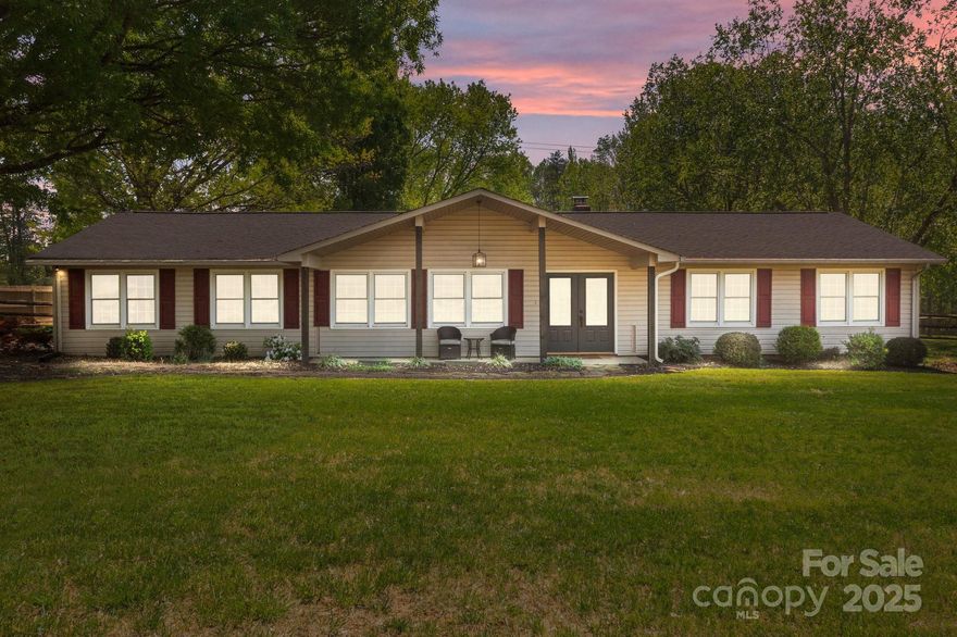 Country living within minutes of downtown dining, shopping & activities in this beautiful 3 bedroom, 2 bath ranch sprawling over 2.5+/- acres on a level corner lot with a 19 x 30 powered workshop and lean-to for extra covered storage. Enjoy the outdoors on your covered rocker porch in front or on your private deck in back. Property has a chicken coup, RV gate, plus additional gates on each side of fence for easy access. Greenhouse & Garden has been prepped - ready for more plantings. Home has been lovingly maintained. All light fixtures were replaced. Nice sized formal living room, Farmhouse Kitchen with custom cabinets, granite counters, breakfast bar, space for a huge dining table and a wood stove with fan inserted in fireplace for those chilly days. Sunny 18.6 X 27.5 Den/Great Room is perfect for entertaining with large windows & access to the outdoors. Roof replaced in 2024. Oversized Laundry room plus a separate mud room off the garage. Primary bedroom has access to the deck.